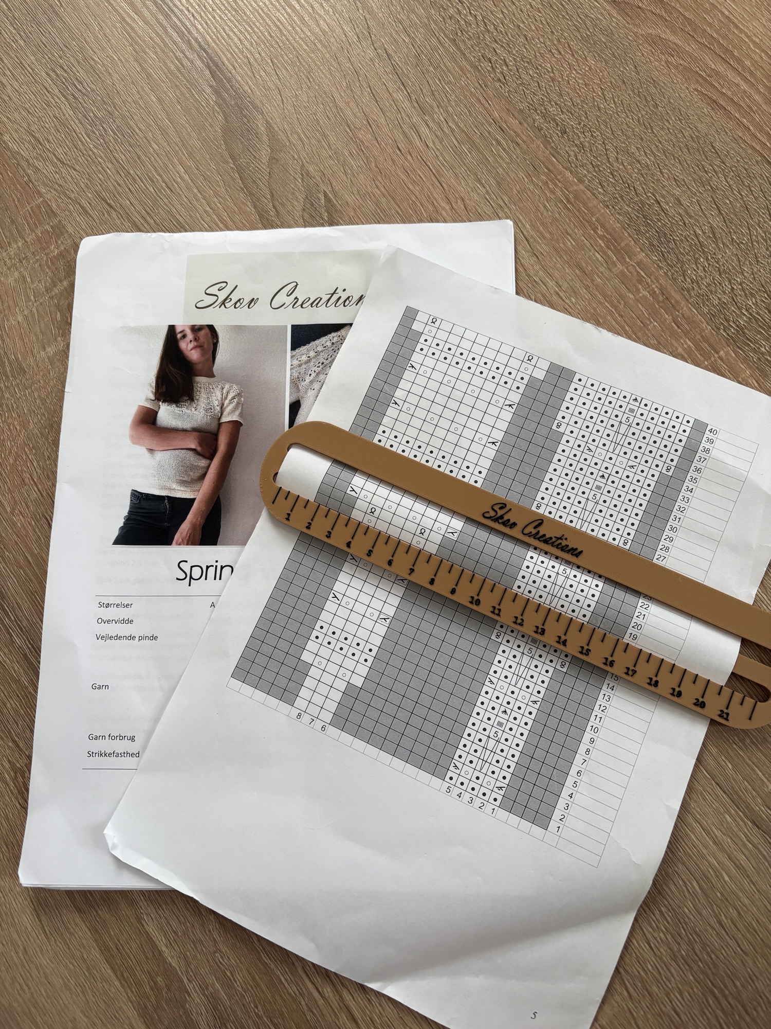 Lukket diagram lineal placeret på udskrevet strikkeopskrift